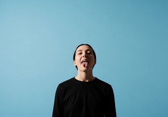 Young woman sticking out tongue against a blue background