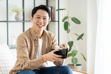 財布を持って喜ぶミドルの男性