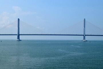 Obraz premium From a distance the landscape of the long Suramadu bridge connecting Java and Madura Island, the blue sky during the day