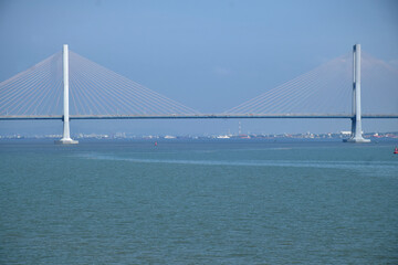 Fototapeta premium From a distance the landscape of the long Suramadu bridge connecting Java and Madura Island, the blue sky during the day