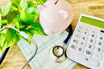 白色の電卓と通帳とブタの貯金箱