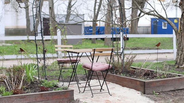 Сhairs and table at outdoor or outside for relax. Backyard with garden furniture set and garden bed for greenery. Interior cozy patio with arch at home.	

