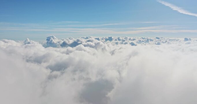 Blue bright sky natural background. Fluffy cumulus clouds float filling frame, creating expansive, soft, ethereal landscape, capturing feeling of peace, tranquility above earth. Aerial drone flight