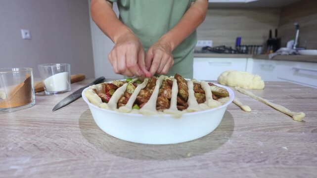 A baker weaves thin dough strips over a filled apple pie in a lattice pattern, meticulous, hands on finishing for a classic homemade dessert.