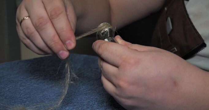 Professional plumber's hands carefully wrapping flax fiber sealant around the threads of a metal pipe fitting to ensure a watertight connection, preparing for plumbing installation or repair work