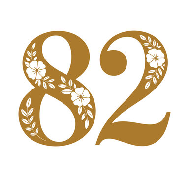A large golden number eighty-two with floral designs on a white background
