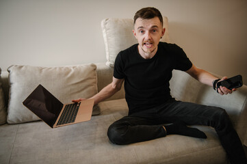 Fototapeta premium Young busy stressed business trader, analyst man reading bad new on the financial market. Male feeling angry working in home office. Investor broker analyzing indexes, trading online investment data.
