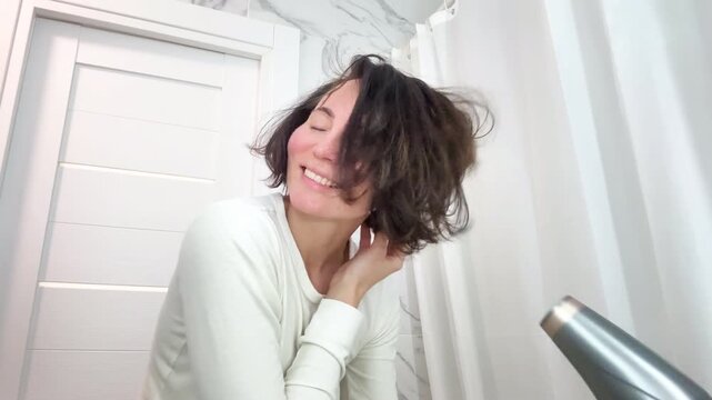 Smiled Woman with Messy Tangled Hair Brushing it with a Hair Dryer in the Morning