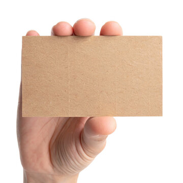 Hand holding blank brown craft paper business card. Cardboard mockup. Isolated on transparent background