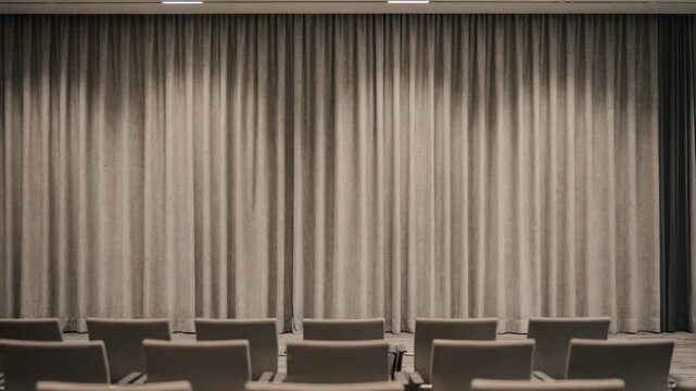 Medium shot capturing widewidth seamless drapes in a conference hall focusing on uniform fabric flow and subtle weave patterns enhancing the professional setting.