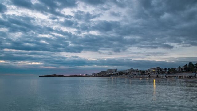Time lapse: Moody seascape at Monastir, Tunisia, Mediterranean sea reflecting dramatic storm clouds and soft light near the horizon, conveying tranquility, travel mood, and coastal atmosphere