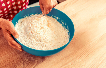 Fototapeta premium Woman kneading dough by hand yeast dough. Female chef preparing dough on kitchen table