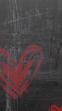Vertical video: Drifting camera reframing large red heart on dark wall, with small red, pink hearts