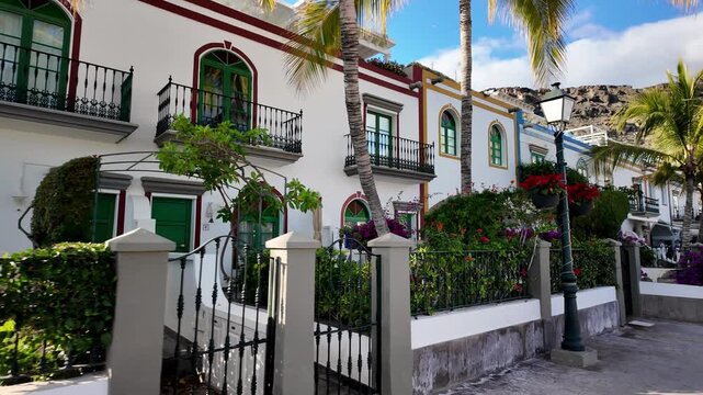 Beautiful buildings with palms and bougainvillea flowers in picturesque fishing old village Puerto de Mogan, Gran Canaria, Canary Islands, Spain
