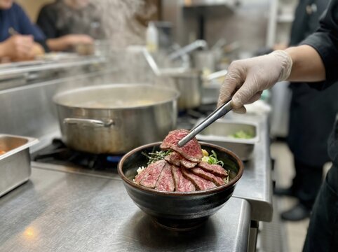 Chef Arranging Thin Sliced Beef on Rice Bowl with Tweezers