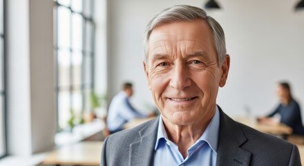 Naklejka premium A smiling elderly man in a suit, with a blurred background of a conference room.