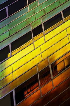 View of vibrant rainbow hues cascade across the geometric facade, where panes of green, yellow, and red glass create an abstract artwork, Almere, Flevoland, Netherlands.