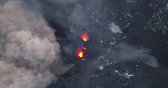 Vanuatu, Tana island, Yasur Volcano active crater erupting incandescent lava, hot ash, dense smoke plumes, raw power of nature and geological activity. Natural phenomena. Aerial drone flight footage