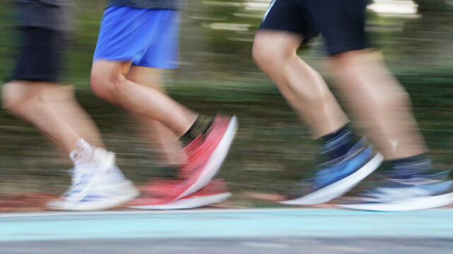 Group of runners in motion blur on a red running path, showcasing the intensity and power of a track meet