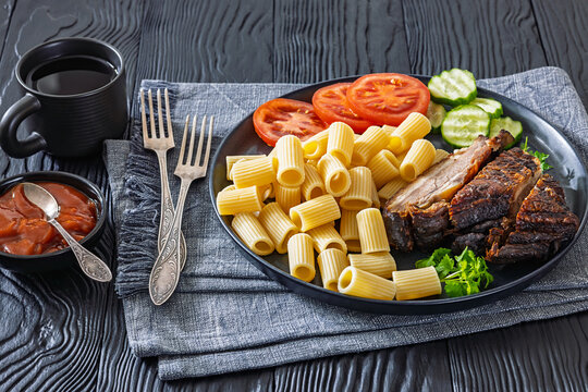 roasted pork ribs with pasta and fresh vegetables