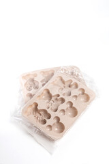 Two silicone baking molds in packaging on white background at angle