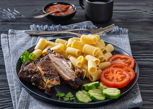 roasted pork ribs with pasta and fresh vegetables