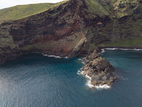 Aerial view of rugged Playa de Nogales cliffs meet the turquoise sea, a panorama of earthy tones contrasting with the ocean's cool embrace, La Palma, Canary Islands, Spain.