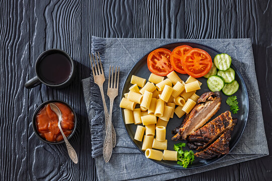 roasted pork ribs with pasta and fresh vegetables