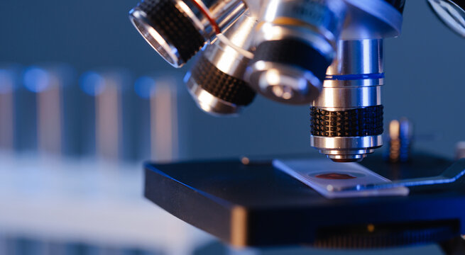 Close-up of microscope with slide in laboratory setting