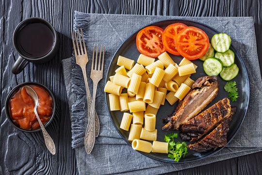roasted pork ribs with pasta and fresh vegetables