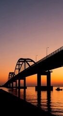 Fototapeta premium Silhouette of bridge over water at sunset.
