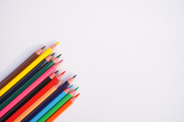 Fototapeta premium A vibrant collection of colored pencils arranged in a fan shape on a white background