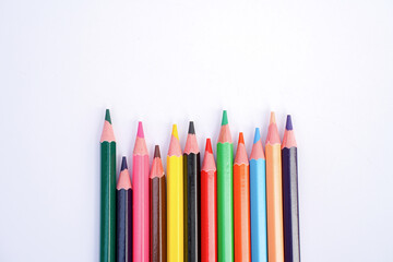 A row of colorful sharpened pencils neatly arranged on a white background