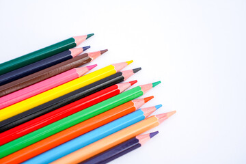 Fototapeta premium a vibrant assortment of colored pencils scattered diagonally against a clean white background