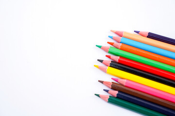 Fototapeta premium A vibrant collection of colored pencils arranged diagonally on a plain white background for art and design