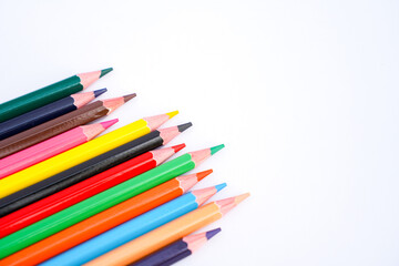 Fototapeta premium A vibrant array of sharpened colored pencils fanned out diagonally against a clean white background