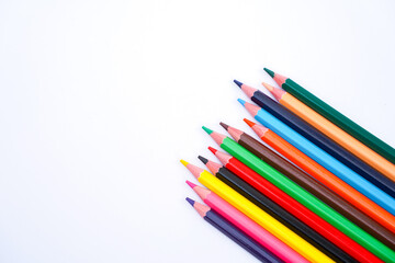 A colorful assortment of sharpened pencils laid out diagonally against a clean white background for creative use