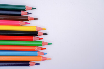 Fototapeta premium A collection of colored pencils arranged in a clean row on a white background