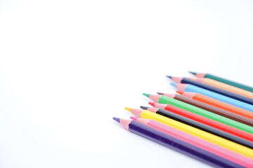 Fototapeta premium bright colored pencils fanned out in a diagonal line on a white background