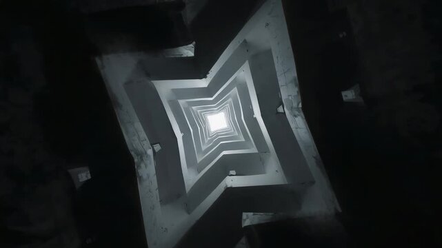 Rotating camera capturing concrete lightwell in shaft, showing stacked balconies and skylight