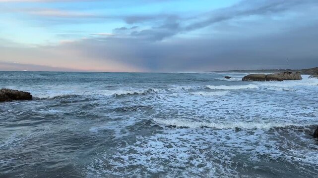 Smooth tidal wave along rocky shore, calm waters, tranquil ocean scene, no people