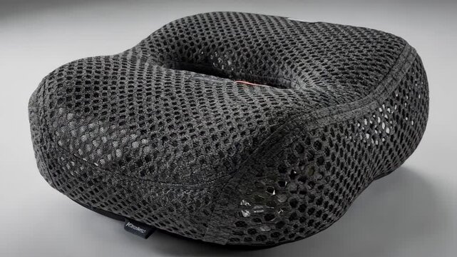 Medium shot focusing on spacer knit technical textiles applied to ergonomic seat covers featuring textured 3D knit fabric that offers cushioning and airflow for added support.