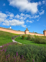 Ancient fortress wall and tower under blue sky with clouds © Katyam1983