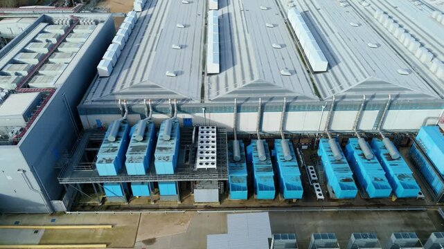 Aerial view of Colt Data Centre Services with its array of cooling systems and white rooftop, Welwyn Garden City, United Kingdom.