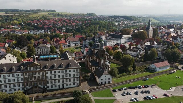 Aerial view of the Baroque Jesuit Church and Mauritius Gymnasium in Buren, Germany, surrounded by a historic townscape.