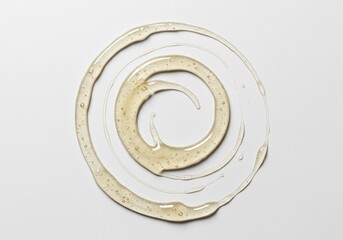 A viscous, clear adhesive substance is arranged in a perfect circular form upon a smooth white background, emphasizing bonding properties ,adhesive ,material ,fluid