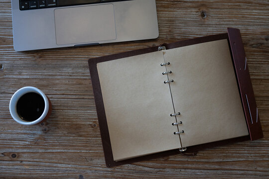 Espace de travail &eacute;pur&eacute; avec ordinateur portable, carnet ouvert et caf&eacute; sur table en bois