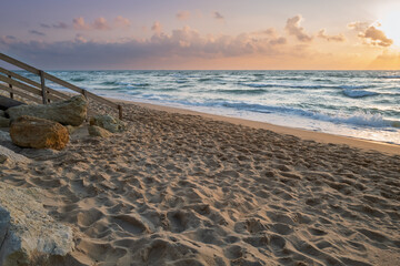 Beach access staircase and Atlantic waves at sunset in Lacanau, France