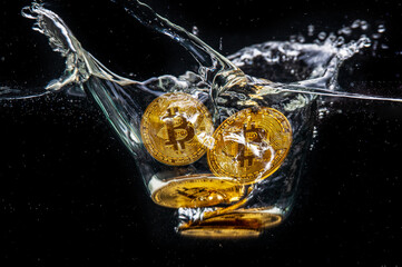 Bitcoin gold coins falling into the water. Splash of gold  crypto coins