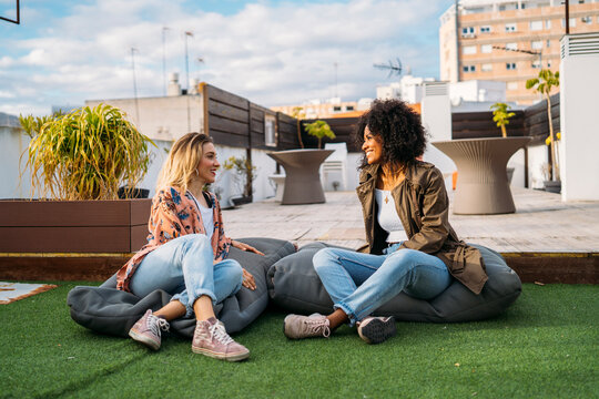 Friends women talking and enjoying rooftop urban lifestyle